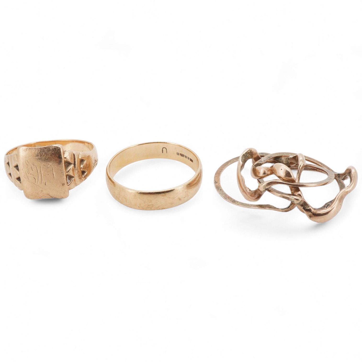 Three gold rings, comprising: a puzzle ring, stamped 14, gross weight approximately 4.5 grams; a signet ring, size Q; and a wedding band, size V, each with British hallmarks for 9ct gold, combined gross weight approximat